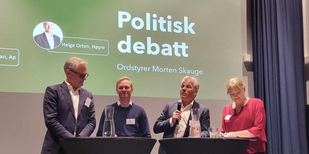 Hans Andreas Limi (FrP), Helge Orten (H), Bjørnar Skjæran (Ap) og Grete Wold (SV) står ved debattbordene under en politisk debatt, med en grønn skjerm bak dem som viser teksten "Politisk debatt" og "Ordstyrer Morten Skauge".