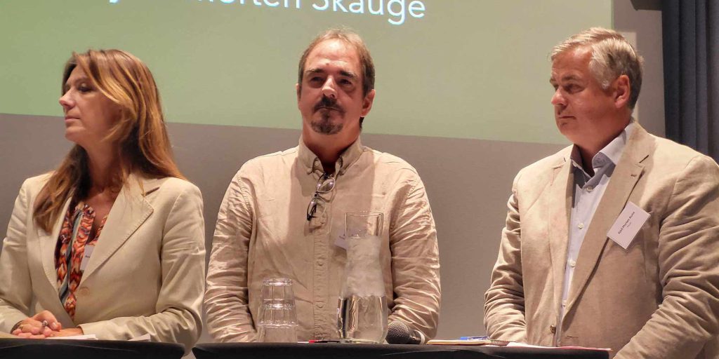 Forbundsleder Brede Edvardsen sammen med Kjell Morten Aune fra Parat og Anne Cecilie Kaltenborn fra NHO Service og Handel står ved siden av hverandre i en debatt på scenen.