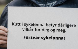 Nærbilde av hender som holder en plakat med teksten: "Kutt i sykelønna betyr dårligere vilkår for deg og meg. Forsvar sykelønna!"