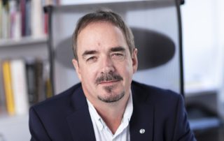 Portrett av Brede Edvardsen, leder i Norsk Arbeidsmandsforbund, sittende på en kontorstol med bokhyller i bakgrunnen. Han ser direkte mot kameraet med et rolig uttrykk.