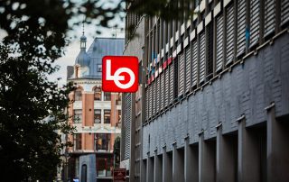 Et stort skilt med LO-logoen henger ut fra ytterveggen til Folkets hus i Oslo.