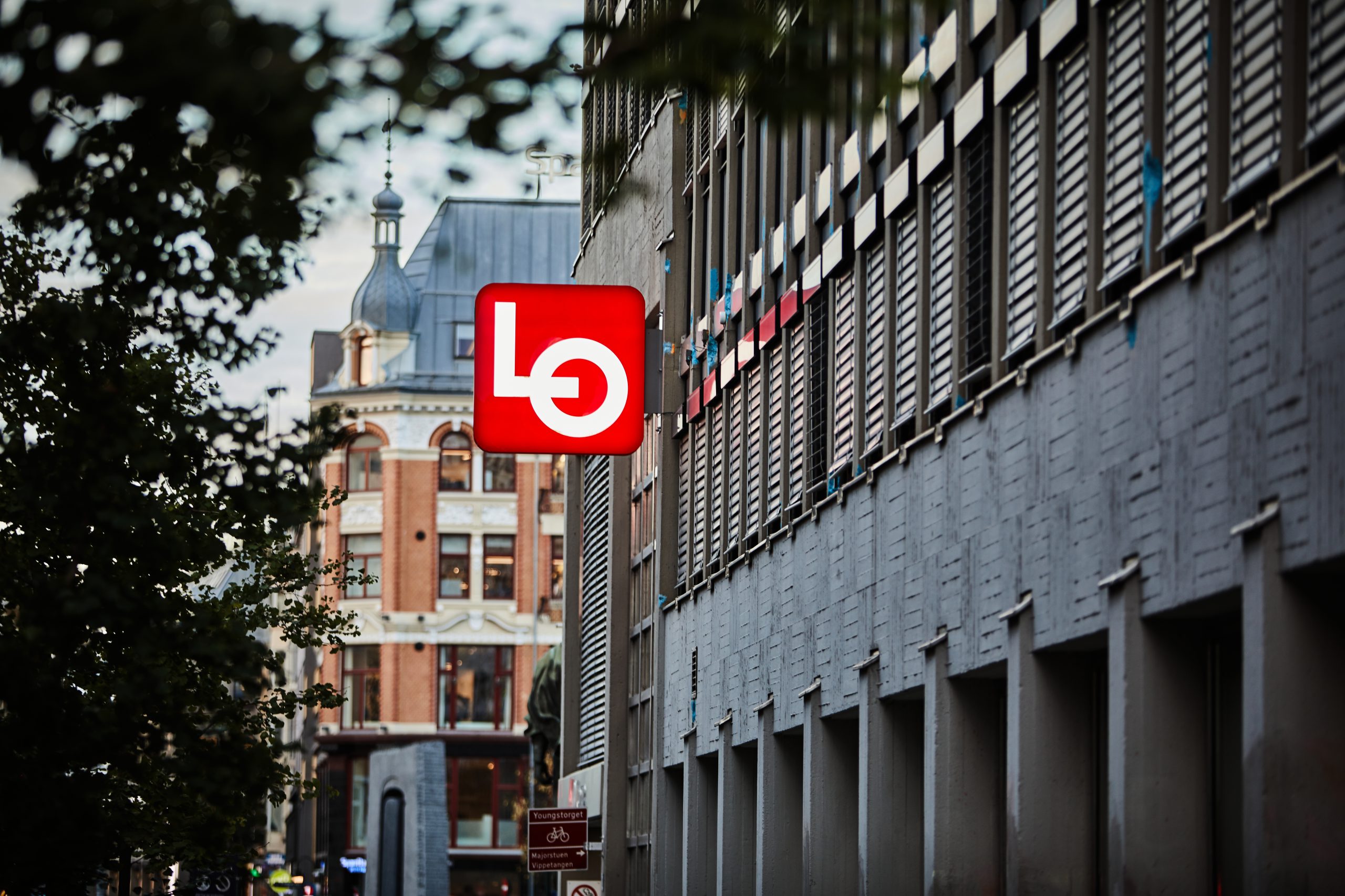 Et stort skilt med LO-logoen henger ut fra ytterveggen til Folkets hus i Oslo.