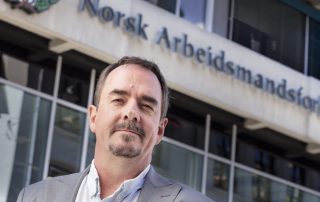 Portrettbilde av Brede Edvardsen utenfor inngangen til Norsk Arbeidsmandsforbund.