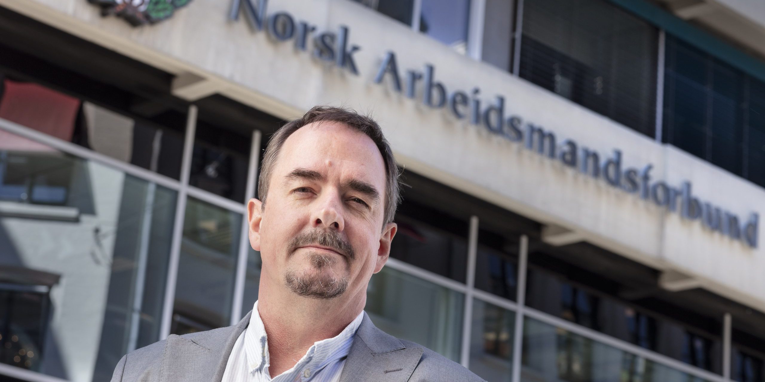 Portrettbilde av Brede Edvardsen utenfor inngangen til Norsk Arbeidsmandsforbund.