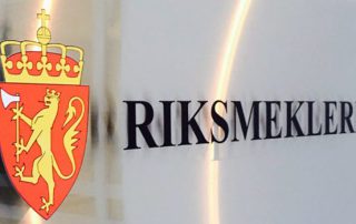 kilt med Riksmeklerens emblem, som viser det norske riksvåpenet med en gul løve som holder en øks på en rød bakgrunn under en krone. Ved siden av emblemet står teksten "RIKSMEKLEREN" i sorte store bokstaver.