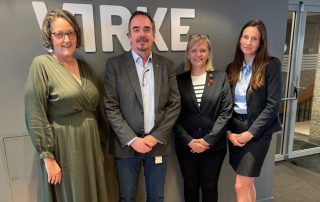 Fire personer står foran en vegg med "Virke"-logoen etter avsluttede forhandlinger mellom Norsk Arbeidsmandsforbund og Virke. Fra venstre: Trine Wiig, Brede Edvardsen, Dorota Anna Miodek og Roksana Kozlowska. De smiler mot kameraet i en profesjonell setting.