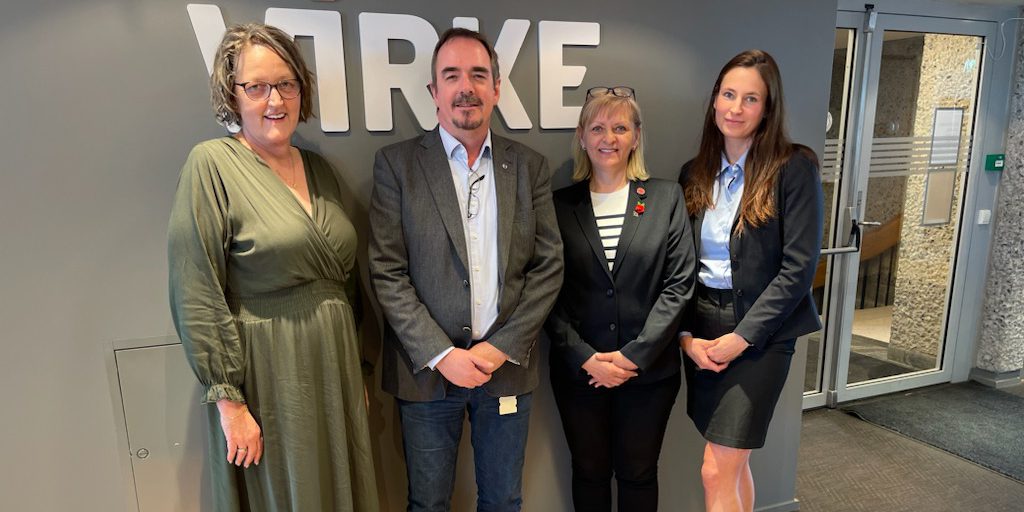 Fire personer står foran en vegg med "Virke"-logoen etter avsluttede forhandlinger mellom Norsk Arbeidsmandsforbund og Virke. Fra venstre: Trine Wiig, Brede Edvardsen, Dorota Anna Miodek og Roksana Kozlowska. De smiler mot kameraet i en profesjonell setting.