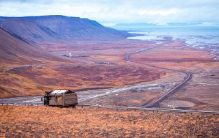Utsikt over Adventdalen-fjorden ovenfra kullgruve nummer 7. Lastebil frakter kull mot havnen, arktisk tundra på Svalbard eller Spitsbergen, Nord-Norge.